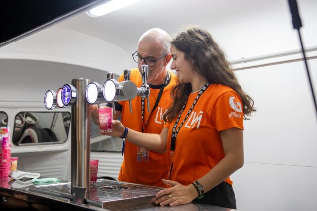 Deux bénévoles sur la tireuse à cocktails. • © Louben Prévost